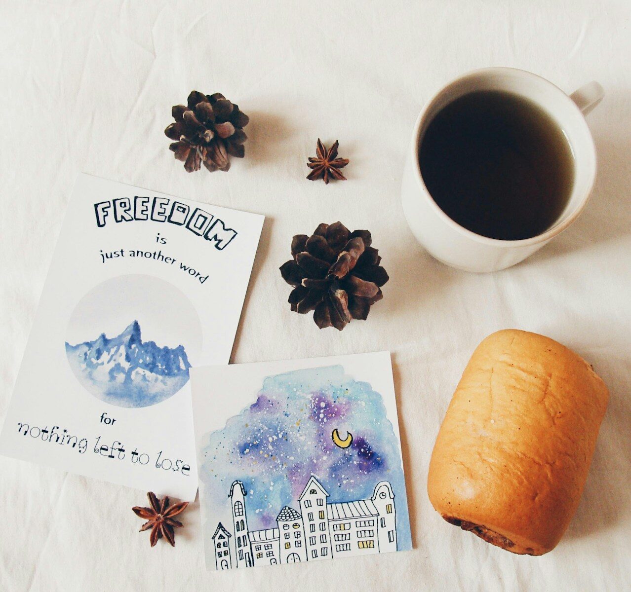 Cozy scene with artwork, pinecones, and a cup of tea.